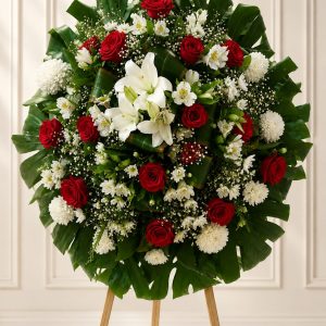 Corona fúnebre premium artesanal con rosas rojas, lirios blancos, flores frescas y follaje natural, elaborada para entrega en funerarias de Guadalajara.