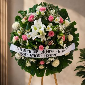 Corona floral premium con rosas rosadas, lirios blancos, flores frescas y follaje natural para funeral y entrega en funerarias de Guadalajara.